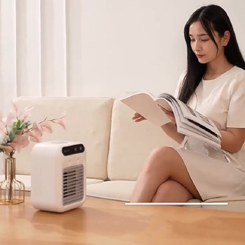 Woman relaxing with a book next to an Air Conditioner Air Cooler Fan on a coffee table.